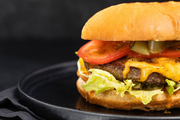 istock Cheese burger with bacon on black dark background 1295796162