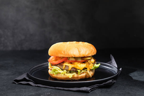 istock Cheese burger with bacon on black dark background 1295796239