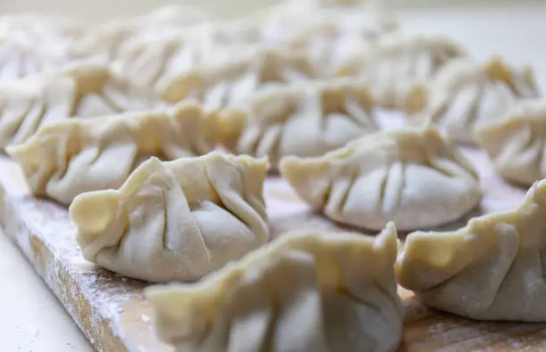 Raw Gyoza. ready for cooking. Japanese version of dumplings. Shallow depth of field. Stock photo
