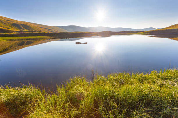 istock quiet mountain lake reflect a sun 1295799843