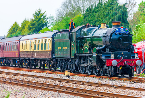 UK steam train on round Britain 9 day tour. Nunney Castle pictured at  Magor in Wales on the 7th day of the tour. Engine is taking on water for the boiler. Engineers are standing on the coal tender supervising this.