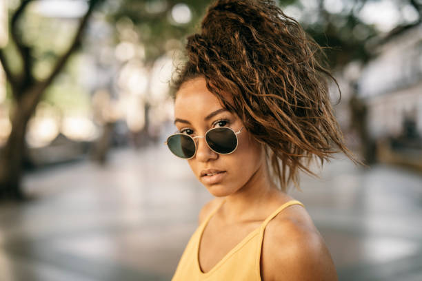 Portrait of confident woman with curly hair, looking at the camera.