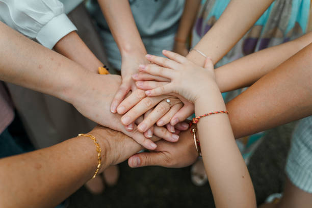 istock Family hands on top of each other together teamwork 1295807434