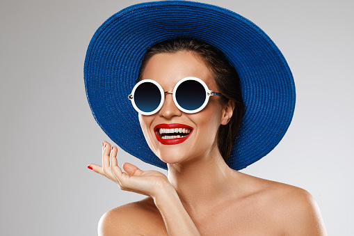 Young and beautiful woman wearing blue hat and sunglasses is ready for vacation