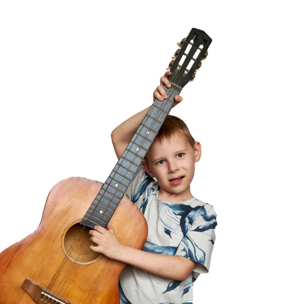 istock Young boy with a guitar. Isolated on white. 1295811331