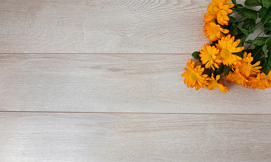 Concept of yellow flowers on wooden background, top view, flat lay.
