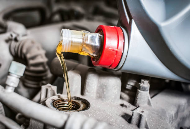 istock Pouring new engine oil into the car engine. Close-up 1295812393