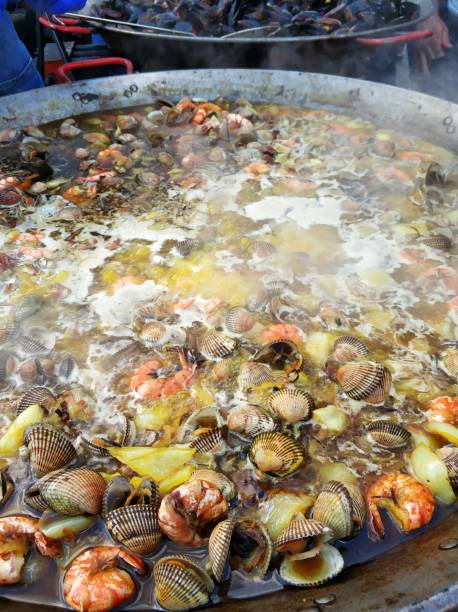 istock Cooking rice with seafood. Mussel shells are boiled in a vat 1295813728