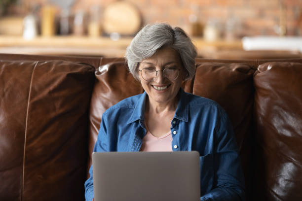 istock Happy middle aged mature woman in eyeglasses using computer. 1295813896