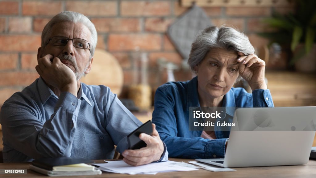 Unhappy older senior family couple thinking of financial problems. Unhappy older senior family couple thinking of financial problems, feeling stressed of banking debt notification or not enough money while calculating budget together at home, bankruptcy concept. Senior Adult Stock Photo