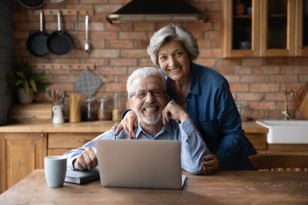 istock Happy middle aged family couple enjoying using computer applications. 1295813959