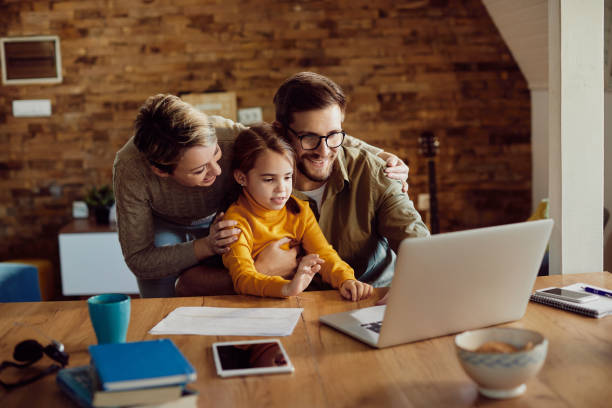 istock Happy family enjoying while using laptop at home. 1295815065
