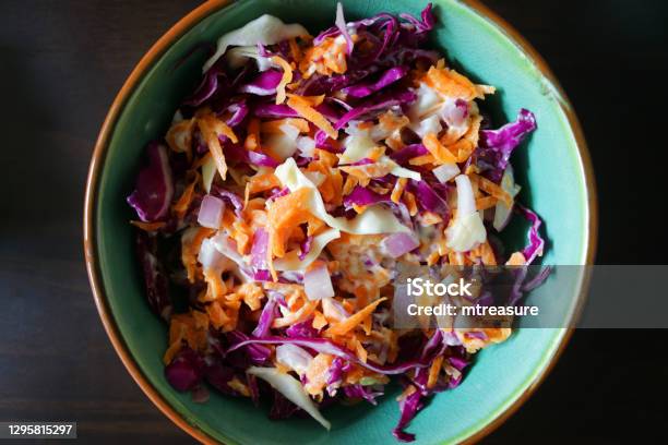 Closeup Image Of Homemade Coleslaw Shredded Red Cabbage Grated Carrot Sliced Onion Mayonnaise Served In Turquoise Blue Bowl On Dark Background Elevated View Stock Photo - Download Image Now