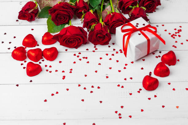 istock St. Valentines Day. Red roses and gift box on wooden table 1295816476