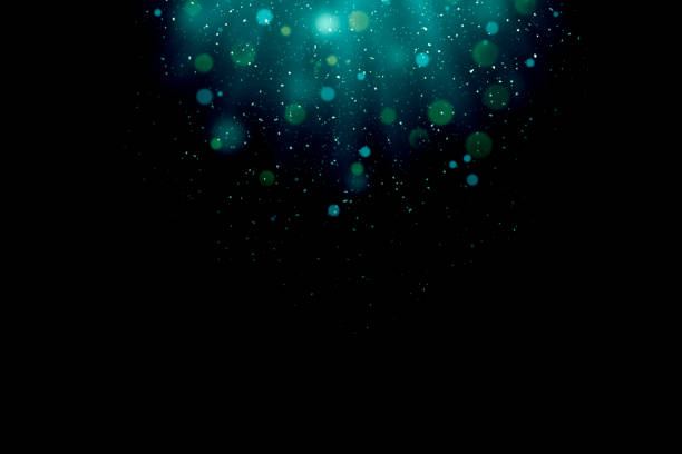 istock Defocused falling lights and dust. Blue-green magical light rays like under water 1295816789