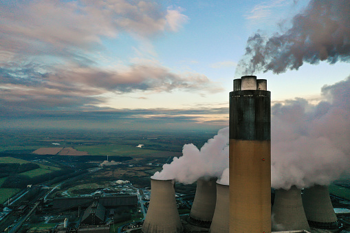 An aerial image of the top of a coal fired power station chimney emitting polluting Carbon Dioxide into the upper atmosphere with copy space