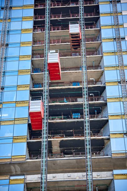 istock Lifts on a glass skyscraper under construction 1295817831