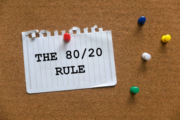un colorido push pins y papel escrito con the 80/20 rule en una tabla de corcho. - pareto fotografías e imágenes de stock