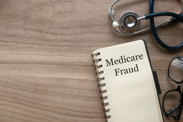 Medicare fraud Top view of stethoscope, glasses and notebook written with Medicare fraud on wooden background with copy space. medicate stock pictures, royalty-free photos & images