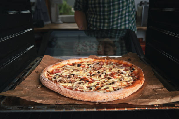 A black man cooking for pizza