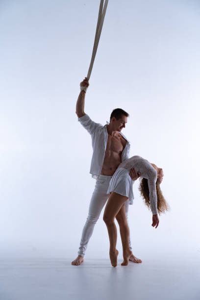 istock Aerial straps duo wearing white costume on white background doing performance 1295822053