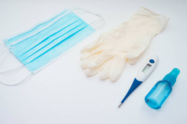 istock face mask, thermometer, gloves and antiseptic on a white background on the table 1295822115