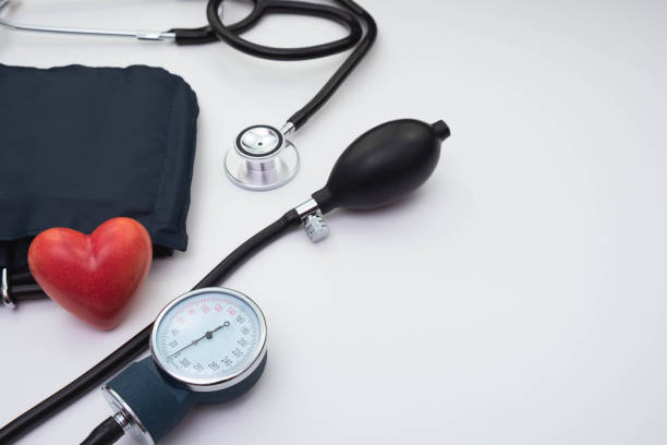 聴診器、圧力計、テーブル上の白い背景�に赤い心臓 - healthcare and medicine digital tablet medical exam doctor ストックフォトと画像