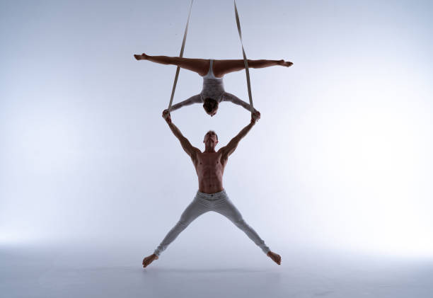 istock Aerial straps duo wearing white costume on white background doing performance 1295822388