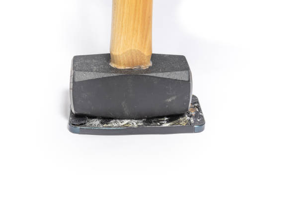 istock Broken and Smashed iPhone lays face up with a sledgehammer laying vertically on the screen. 1295823202
