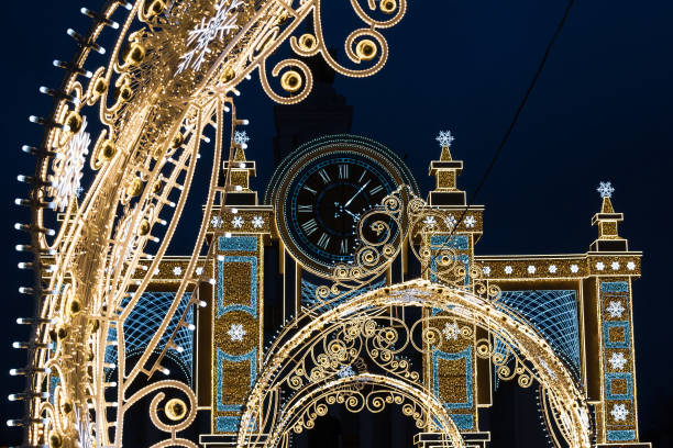 美しいオープンワー��クの光のアーチと時計 - vdnkh公園のクリスマスストリートの装飾 - vdnh ストックフォトと画像