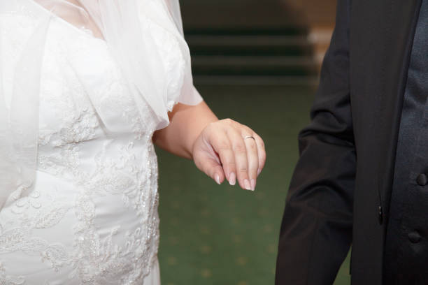 istock Bride's hand with a wedding ring near the groom 1295829087