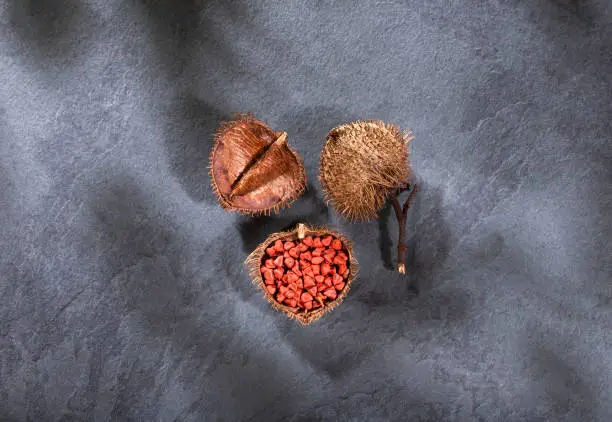 Bixa Orellana - annatto organic seeds. Wood background