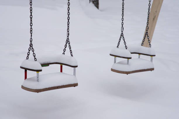 istock swing at the playground covered in snow 1295830916