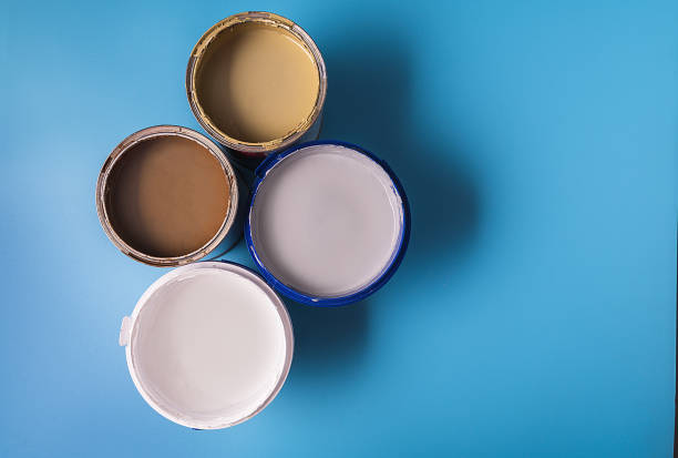 istock Cans with paint of different colors on blue background. 1295832335
