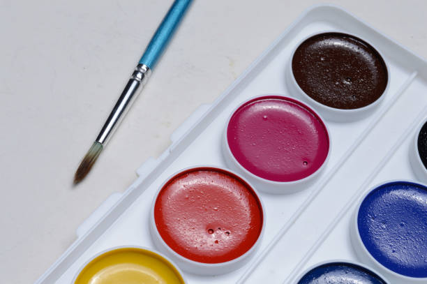 istock multicolored paints for drawing in a palette and a brush. on a light background close-up. 1295832458