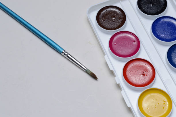 istock multicolored paints for drawing in a palette and a brush. on a light background close-up. 1295833072