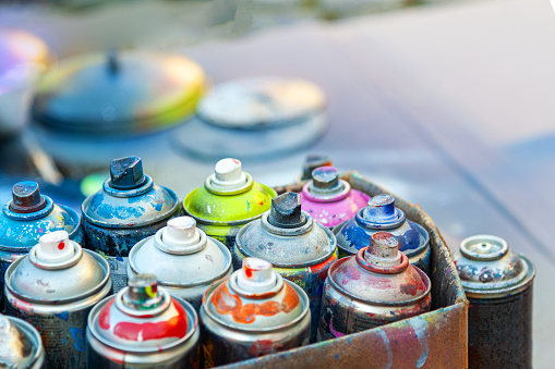 Used aerosol spray paint in cans in carton .