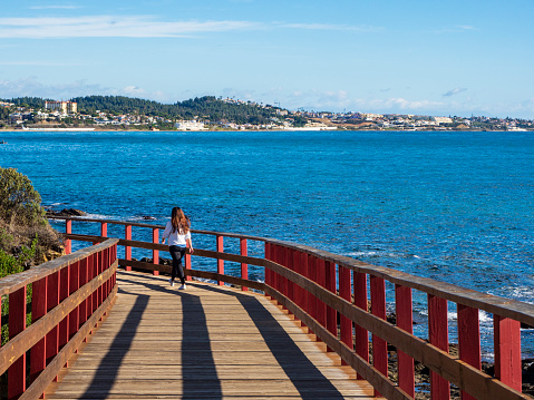 Mijas, Andalusia, Spain.  November, 2020 .  Tourists walking on the wooden path of the Mijas coast on a sunny autumn day.