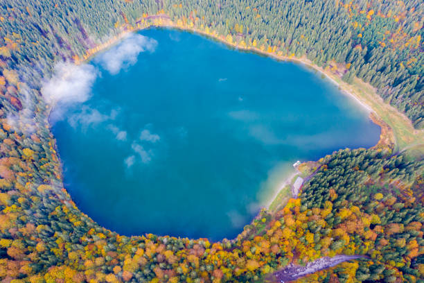 istock Morning clouds over green mountain lake during autumn 1295836209