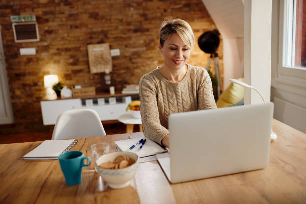 istock Happy woman using laptop while working at home. 1295837246