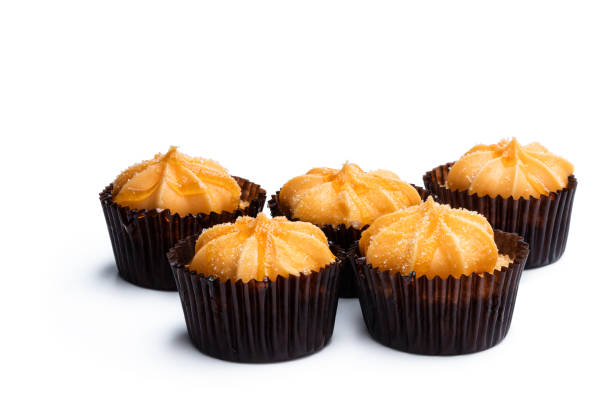 istock Mini sponge cakes with orange buttercream topped isolated on white 1295839384
