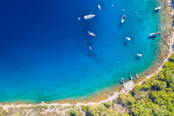 An aerial view of a blue bay of water with moored yachts and sailing boats stock photo