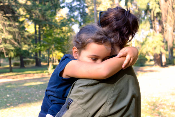 istock Affectionate mother and daughter embracing at the park. 1295842303