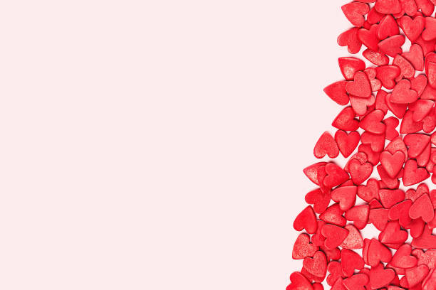 istock Uneven frame of Heart shaped red sprinkles pattern background banner 1295842955