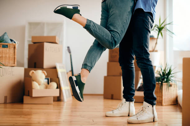 istock Unrecognizable couple having fun while moving into a new home. 1295844738