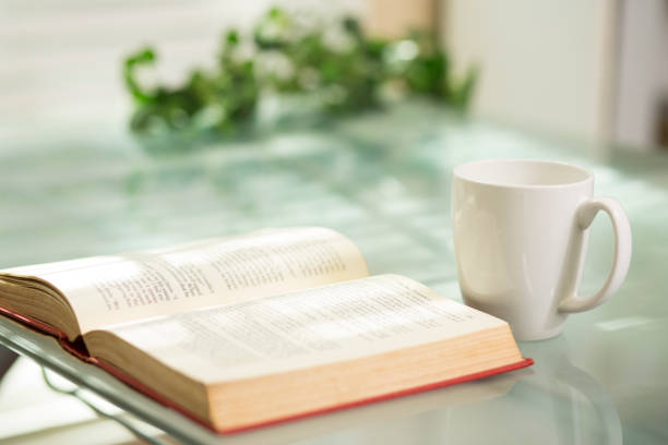 istock A single coffee mug sit on glass top table near an open book.. 1295845139