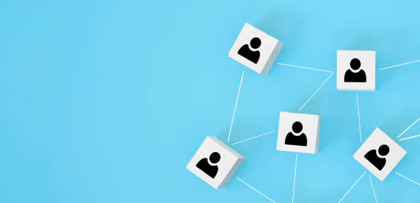 istock Organization structure, team building, recruitment, business management and human resources concepts. Person icons on wooden cubes linked to each other. 1295845262