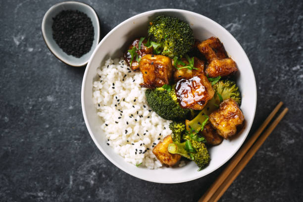 istock Asian vegan bowl with rice, broccoli and fried tofu 1295845895