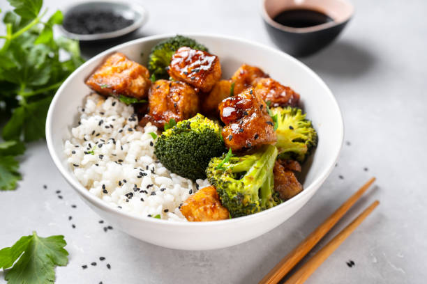 istock Asian vegan bowl with rice, broccoli and fried tofu 1295845897