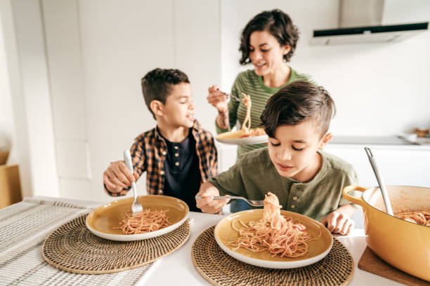 istock Kids eating pasta. Lunch at home 1295846246